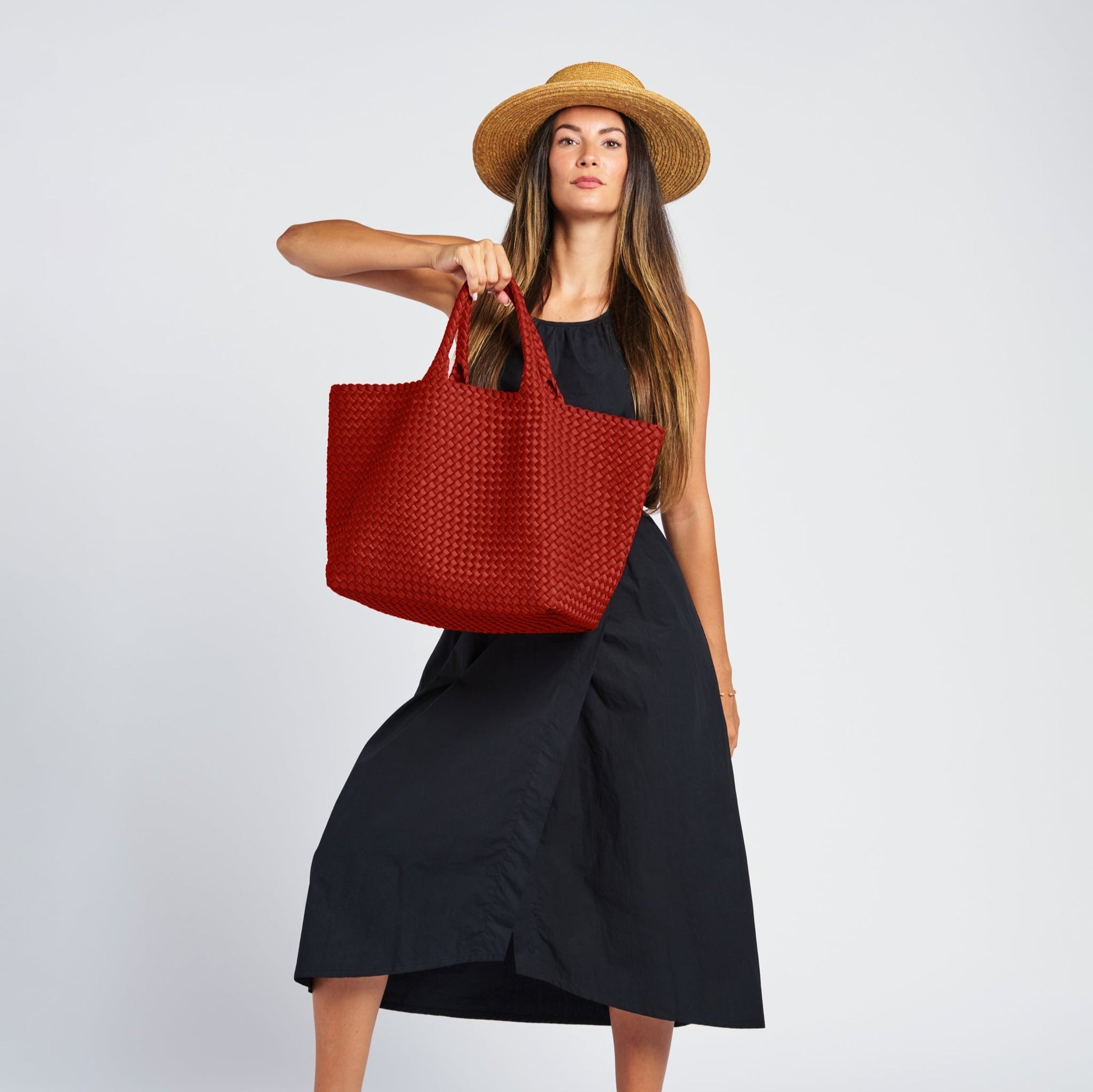 woman in a black dress with a terracotta large neoprene tote wearing a hat