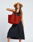 woman in a black dress with a terracotta large neoprene tote wearing a hat